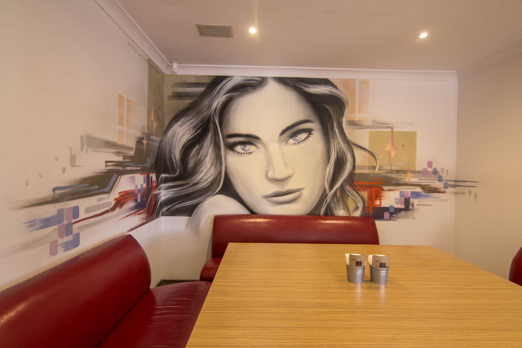 Graffiti mural portrait inside restaurant.