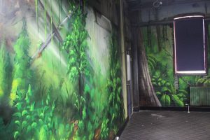 Three-wall urban rainforest spray paint wall mural interior.