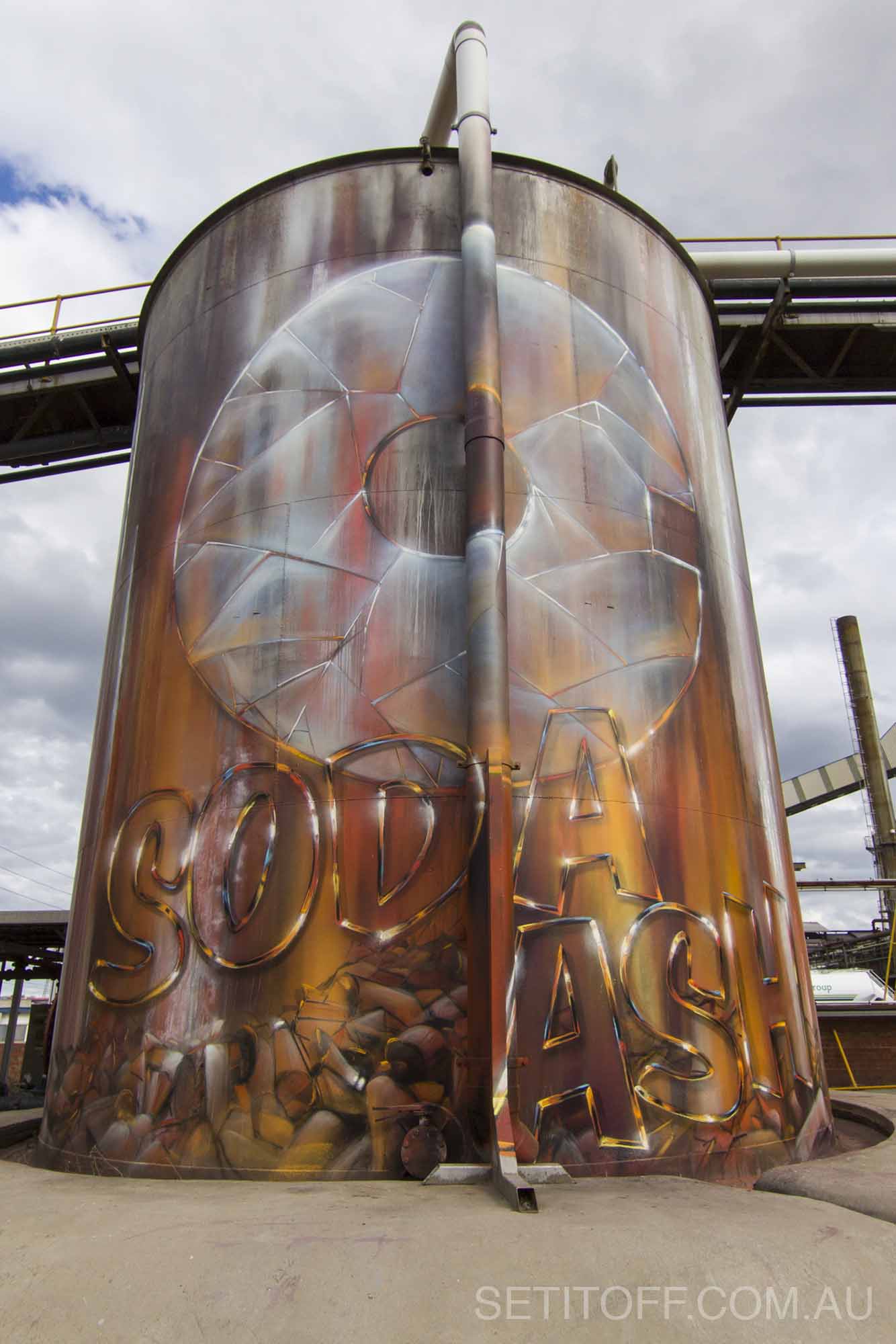 Old, industrial silos are restored with graffiti art representing the company that owns them.