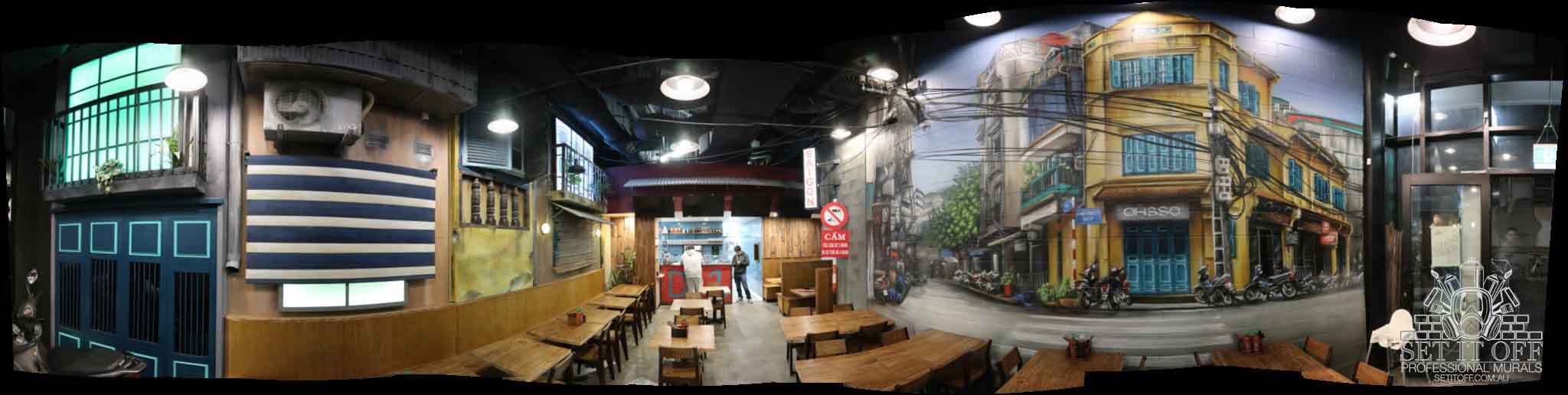 Continuous wall murals throughout a Vietnamese restaurant combined with other recycled materials and sculptures.