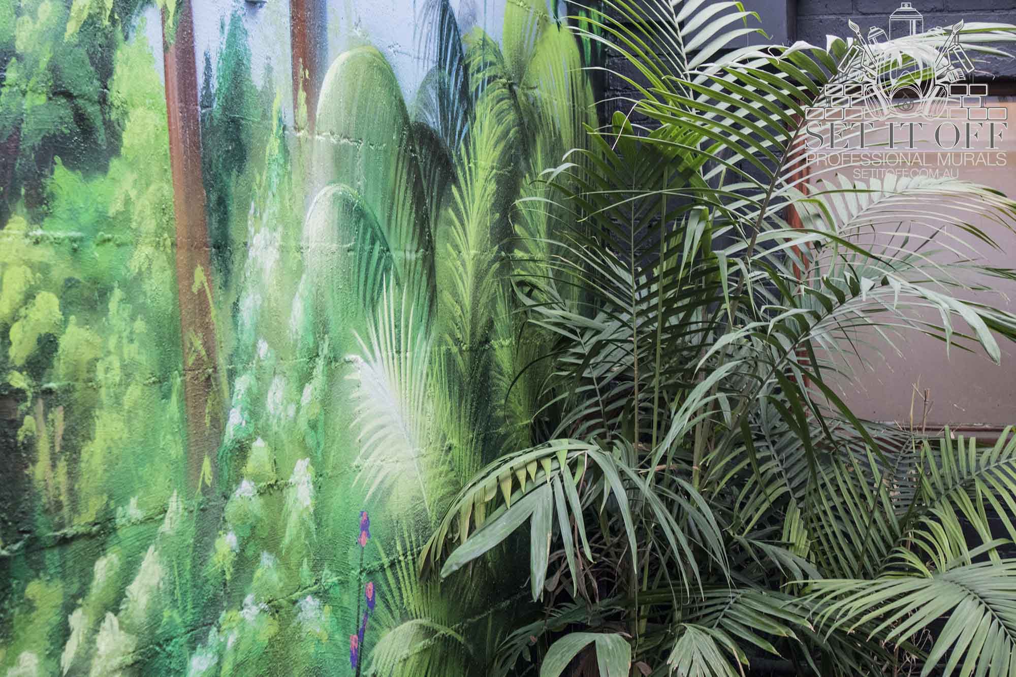 A tropical wall mural inside Forest cafe courtyard.